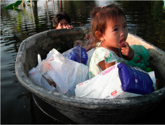 ภาพเด็กนั่งอยู่ในภาชนะที่ลอยน้ำได้